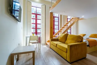a bedroom with a bed and a staircase at Close to Everything Your Oporto Yellow PRM 1F in Porto