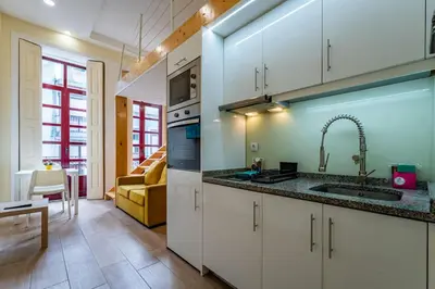 a kitchen with white cabinets and a sink at Close to Everything Your Oporto Yellow PRM 1F in Porto