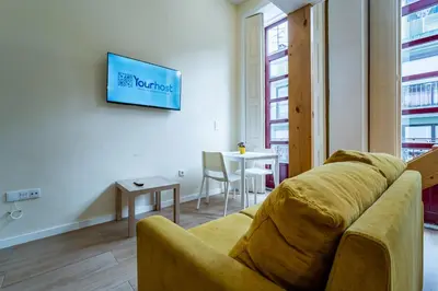 a living room with a yellow couch and a bed at Close to Everything Your Oporto Yellow PRM 1F in Porto