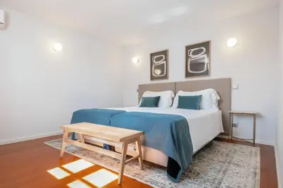 a bedroom with a bed with a blue blanket and a table at Feel Porto Ribeira Vintage Duplex in Porto