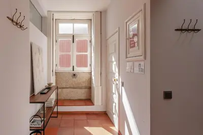 a hallway with a door and a window and a staircase at Feel Porto Ribeira Vintage Duplex in Porto