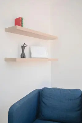a blue couch with a book on a shelf at Liiiving in Porto - Downtown Balcony Apartment in Porto