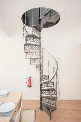 a metal spiral staircase in a room at Liiiving in Porto - Downtown Balcony Apartment in Porto