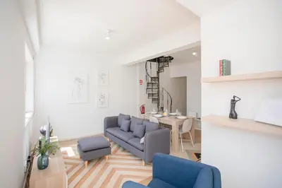 a living room with a blue couch and a table at Liiiving in Porto - Downtown Balcony Apartment in Porto