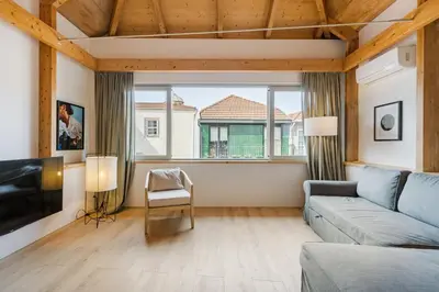 a living room with a couch and a large window at GuestReady - Cedofeita Collection Apartments in Porto