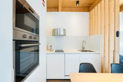 a kitchen with white cabinets and a stove at GuestReady - Cedofeita Collection Apartments in Porto