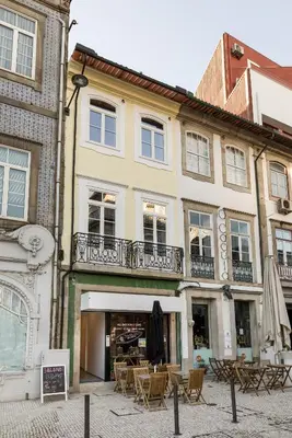 a building with tables and chairs in a courtyard at Clérigos Apartments Porto - Ferradores in Porto