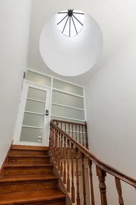 a stairway with a glass door and a circular light at Clérigos Apartments Porto - Ferradores in Porto