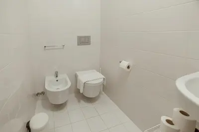 a white bathroom with a toilet and a sink at Stylish Flat by Hosty in Porto