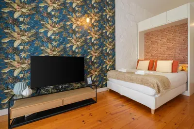 a bedroom with a bed and a tv on a wall at Historic Porto Nook Downtown Porto near metro in Porto