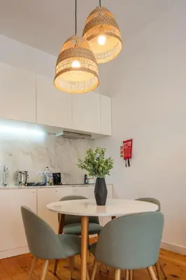 a kitchen with a table with chairs and two lights at Historic Porto Nook Downtown Porto near metro in Porto
