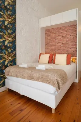 a bedroom with a large bed with a brick wall at Historic Porto Nook Downtown Porto near metro in Porto