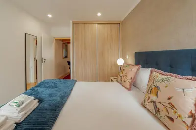 a bedroom with a bed with white sheets and pillows at City Center Comfort Apartment by Vacationy in Porto