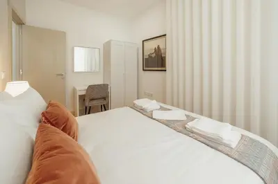 a bedroom with a large bed with a blue headboard at City Center Comfort Apartment by Vacationy in Porto