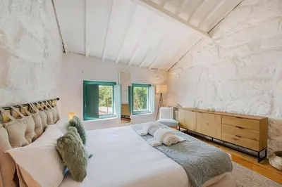 a bedroom with a large bed in a stone wall at GuestReady - A special place in Porto in Porto