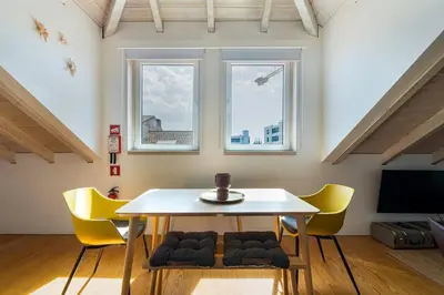 a dining room with a white table and yellow chairs at GuestReady - A Porto Nest with a Twist in Porto