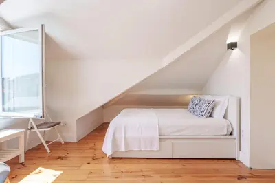 a white bedroom with a bed and a desk at VIVA Loft in Historic Center Porto in Porto