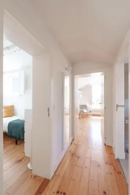 a white bedroom with a bed and a wooden floor at VIVA Loft in Historic Center Porto in Porto