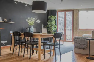 a dining room with a wooden table and black chairs at Spot Apartments Sao Bento in Porto