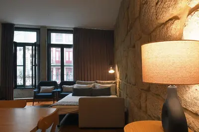 a living room with a couch and a lamp at Spot Apartments Sao Bento in Porto