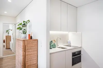 a kitchen with white cabinets and a sink at GuestReady - Unfolded in Porto