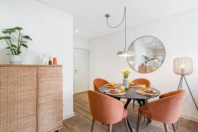 a dining room with a table and chairs and a mirror at GuestReady - Unfolded in Porto