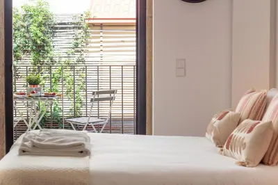 a bedroom with a bed and a balcony with a table at Santa Teresa Studio by LovelyStay in Porto