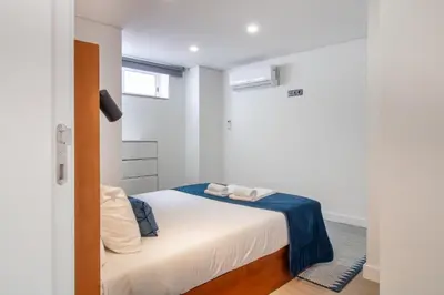 a bedroom with a white bed and a window at Quiet Duplex w Patio in Lapa by LovelyStay in Porto