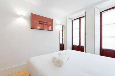 a bedroom with a white bed with towels on it at GuestReady - Clérigos Tiles House in Porto