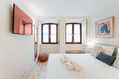 a bedroom with a white bed with towels on it at GuestReady - Clérigos Tiles House in Porto