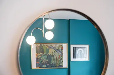 a mirror in a room with a painting and lights at GuestReady - Peaceful retreat near Casa da Música in Porto