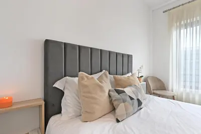 a bed with a black headboard and pillows on it at White Stripes House of Music in Porto