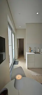 a kitchen and living room with a table and a tv at Apartamento D'Alegria in Porto