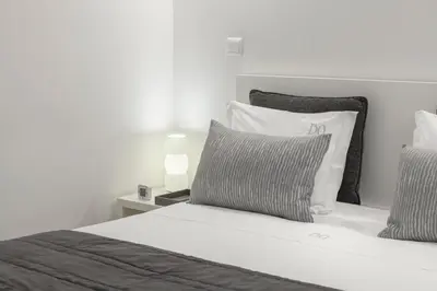a bedroom with a white bed with two pillows at BO - Almada in Porto