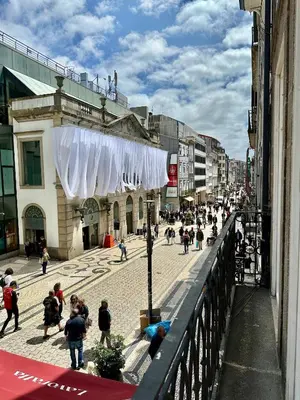 a crowd of people walking down a city street at YOUROPO - Capela in Porto