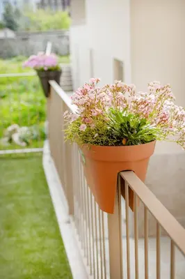 a flower pot on a fence with flowers on it at The Superior Green @ BoaVista Flats in Porto