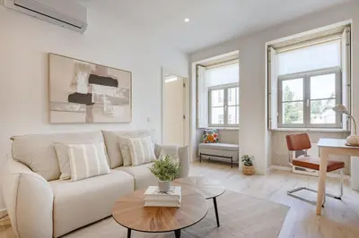 a living room with a white couch and a tv at The Soft Escape @ BoaVista Flats in Porto