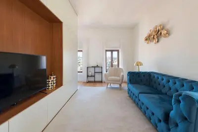 a living room with a blue couch and a tv at Porto Riverviews | Monte dos Judeus in Porto