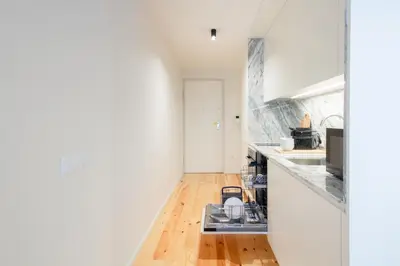 a kitchen with white cabinets and a sink at Luxurious Studio Retreat in Porto by LovelyStay in Porto