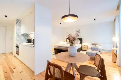 a kitchen and living room with a table and chairs at Luxurious Studio Retreat in Porto by LovelyStay in Porto