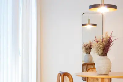 a table with a mirror and a vase with flowers at Luxurious Studio Retreat in Porto by LovelyStay in Porto