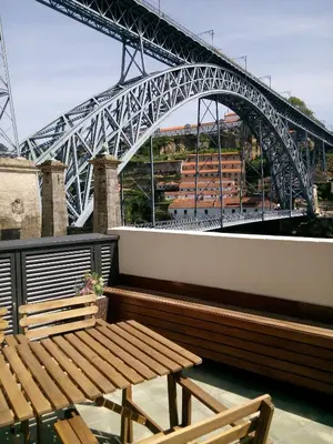 a bridge over a river with a wooden bench at Oporto Welcome Apartments - Ribeira Negra in Porto