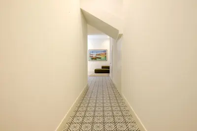 a hallway with white walls and a carpeted floor at Art Deco 32 Luxury 2BR Apartment Downtown Metro AC in Porto