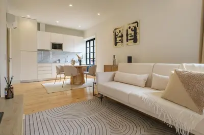 a living room with a white couch and a kitchen at Art Deco 32 Luxury 2BR Apartment Downtown Metro AC in Porto