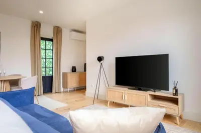 a living room with a tv and a blue couch at Art Deco 42 Luxury 2BR Apartment Downtown Metro AC in Porto