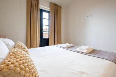 a bedroom with a white bed with a window at Art Deco 42 Luxury 2BR Apartment Downtown Metro AC in Porto