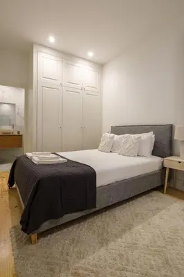 a bedroom with a large bed with a black blanket at Art Deco 13 Luxury 2BR Apartment Downtown Metro AC in Porto