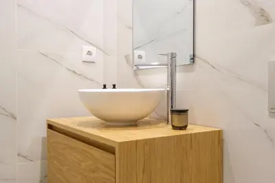 a bathroom with a white bowl sink on a wooden stand at Art Deco 13 Luxury 2BR Apartment Downtown Metro AC in Porto