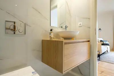 a bathroom with a bowl sink on a wooden vanity at Art Deco 23 Luxury 2BR Apartment Downtown Metro AC in Porto