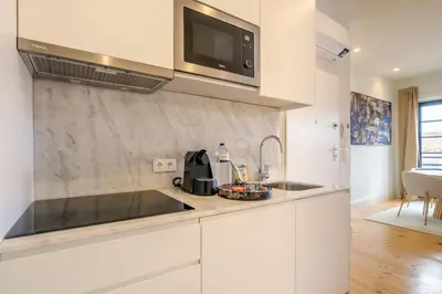 a kitchen with a sink and a microwave at Art Deco 33 Luxury 2BR Apartment Downtown Metro AC in Porto
